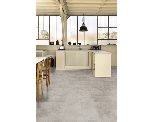 Heller Raum mit Betonboden, Küchenzeile und großen Fenstern.