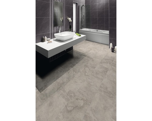 Modernes Badezimmer mit Badewanne, Waschbecken und grauen Fliesen.