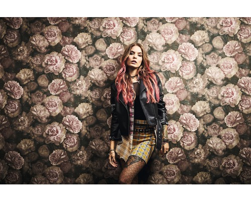 Femme devant un mur avec un motif floral