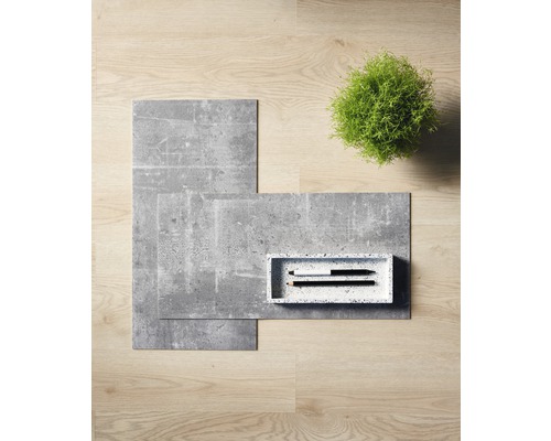 Carreaux de sol décoratifs imitation pierre, un petit plateau avec des stylos et une plante verte sur un plancher en bois.
