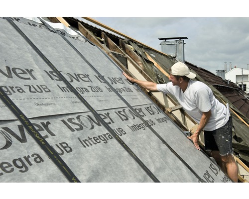 Couvreur pose un écran de sous-toiture Isover sur un toit.