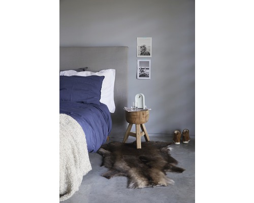 Chambre à coucher avec lit, tapis en peau et tabouret en bois