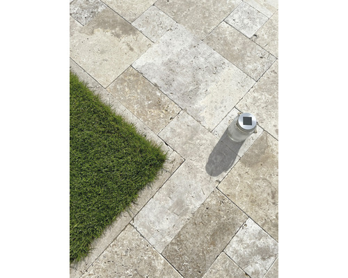 Dalles en pierre naturelle posées à l''extérieur avec pelouse et lampe solaire