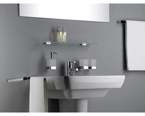 Badezimmer Waschbecken mit Armatur, Seifenspender, Zahnputzbecher, Glasablage und Handtuchhaltern in einem hellen Badezimmer