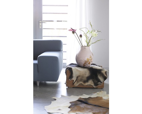 Wohnzimmer mit Sofa, Vase und Fellteppich