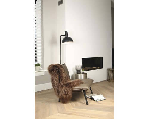 Modernes Wohnzimmer mit Sessel, Lampe und Kamin