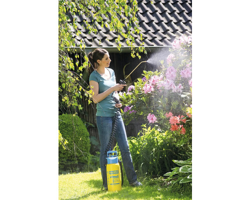 Frau benutzt Gloria Prima 5 Drucksprüher im Garten zur Pflanzenpflege
