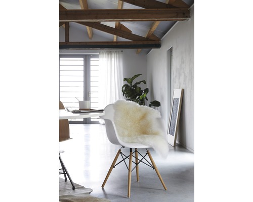 Esszimmer mit Tisch, Stühlen und Schaffellauflage