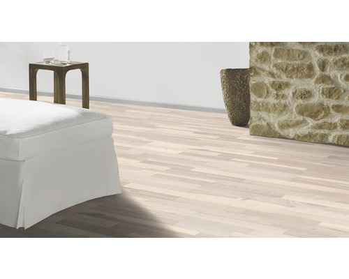 Heller Holzboden in einem Wohnraum mit Steindekoration und weißen Möbeln.