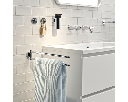 Salle de bains avec lavabo, robinet, distributeur de savon, serviette et porte-serviettes.