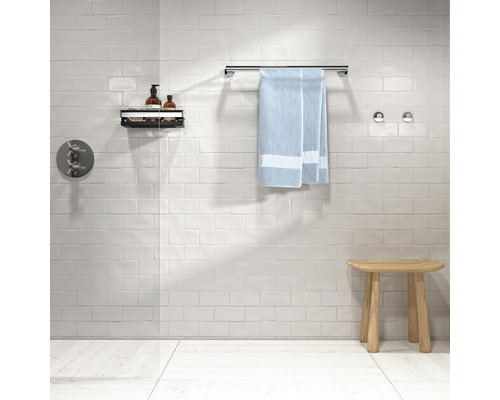 Salle de bains avec robinetterie, serviette, étagère et tabouret