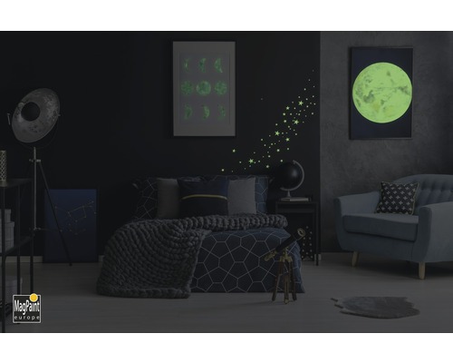 Chambre avec lit, fauteuil et décorations murales lumineuses de lune et d''étoiles