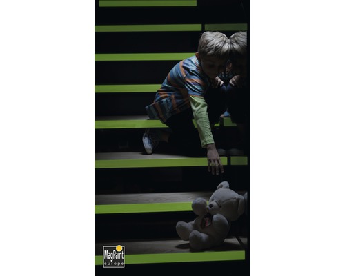 Garçon sur un escalier avec de la peinture luminescente et un ours en peluche