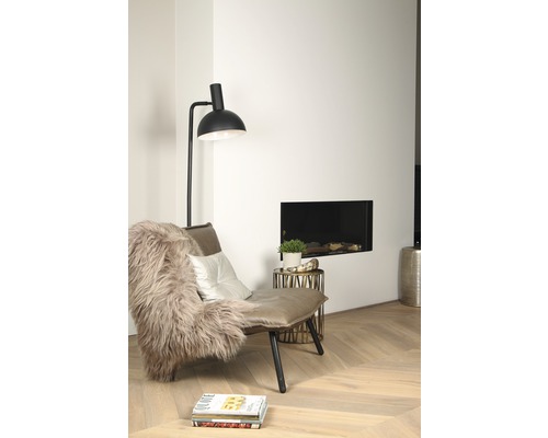 Wohnzimmer mit Sessel, Stehlampe und Kamin für eine gemütliche Atmosphäre.