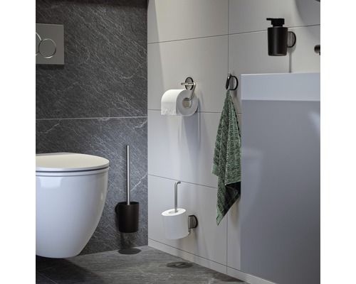 Salle de bains moderne avec toilettes, porte-papier toilette, serviette et distributeur de savon