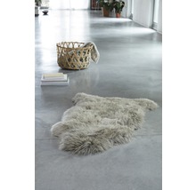 Pièce claire avec tapis en peau de mouton, pile de livres et panier