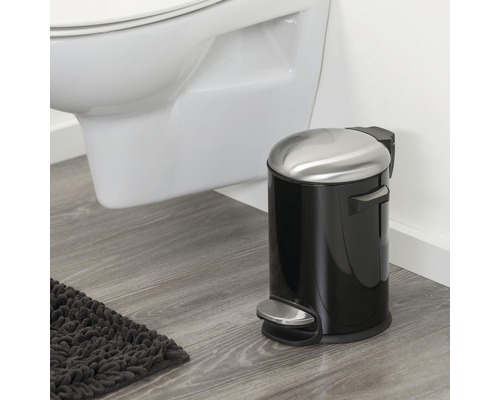 Poubelle à pédale en métal et plastique dans une salle de bain, à côté de toilettes