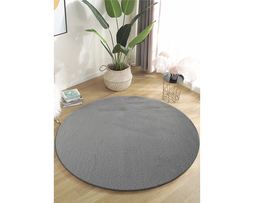 Runder, grauer Teppich in einem hellen Raum