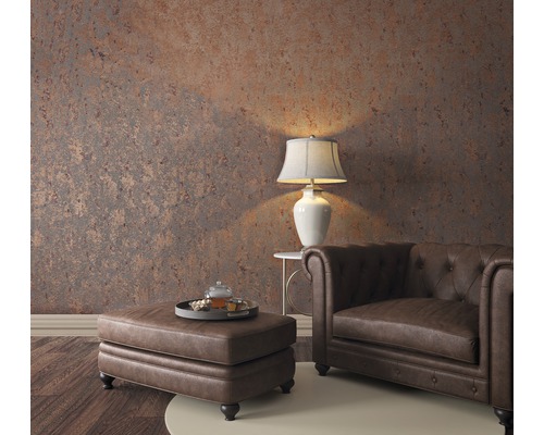 Salon avec fauteuil Chesterfield, ottoman, lampe de table et papier peint à motifs pour une ambiance chaleureuse