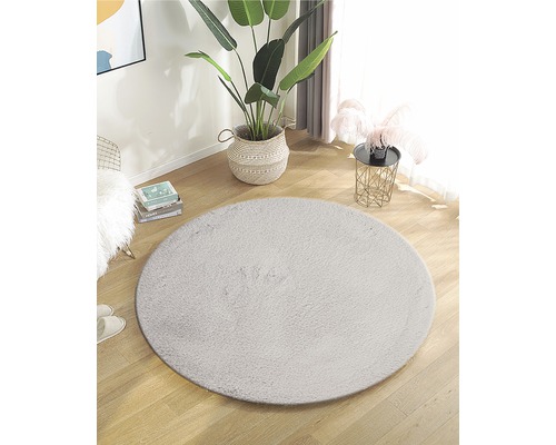 Aménagement avec tapis rond en fibre synthétique sur plancher en bois dans une pièce lumineuse.