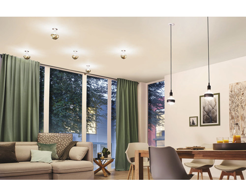 Wohnzimmer mit Sofa, Esstisch und verschiedenen Deckenleuchten.