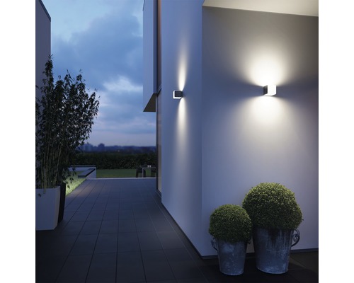 Moderne Hausfassade mit quadratischen Wandleuchten und dekorativen Pflanzen