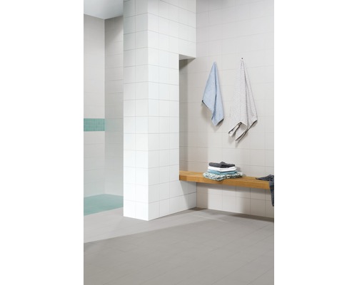 Modernes Badezimmer mit weißen Fliesen, Holzbank und Handtüchern