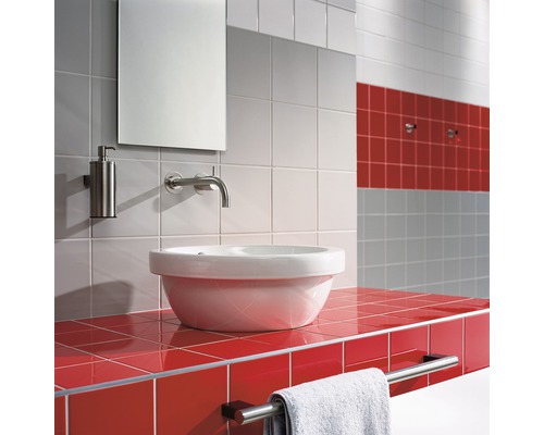 Badezimmer mit Waschtisch, Spiegel, Seifenspender und Handtuchhalter