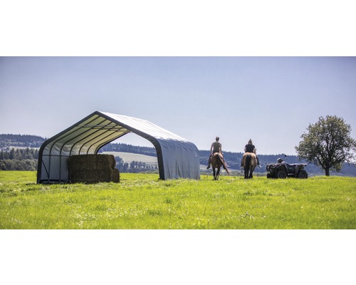 Hangar à foin avec bottes de foin et personnes à cheval et en quad