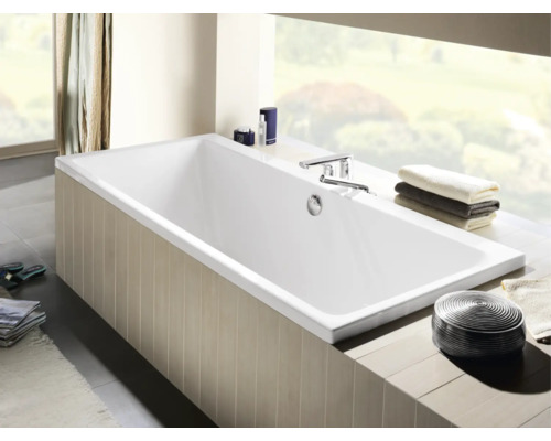 Rechteckige Badewanne im Badezimmer mit Armaturen und Handtüchern