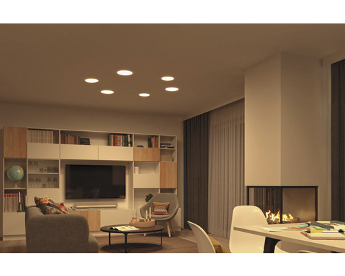 Wohnzimmer mit Einbaustrahlern in der Decke, Bücherregal, Fernseher und Kamin.