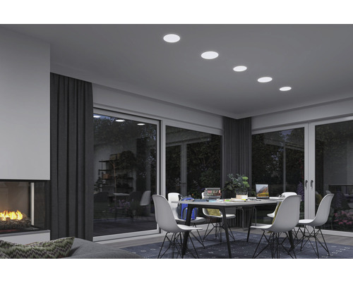 Wohnzimmer mit Esstisch, Stühlen und Deckeneinbaustrahlern für eine helle Atmosphäre.