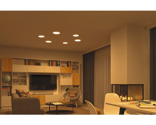 Wohnzimmer mit Deckeneinbaustrahlern, Bücherregal, Fernseher und Kamin