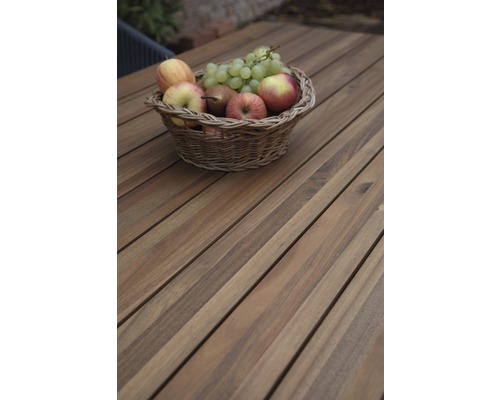 Panier avec pommes, poires et raisins sur une table en bois