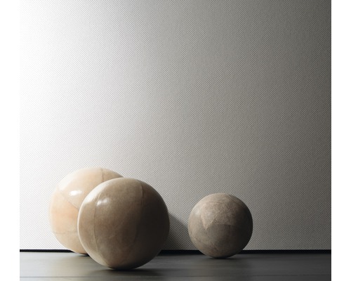 Gros plan sur trois boules décoratives devant un mur structuré