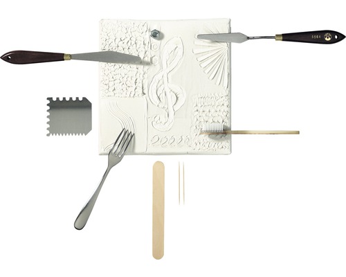 Divers outils de modelage et une plaque de relief avec une clé musicale
