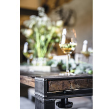 Vue détaillée d''une table avec pieds en métal, plateau en bois, décorations florales et verres à vin