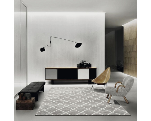 Wohnzimmer mit Sideboard, Teppich, Sesseln und Wandleuchte