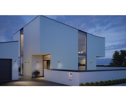 Modernes Haus mit Aussenbeleuchtung und grossen Fenstern bei Dämmerung