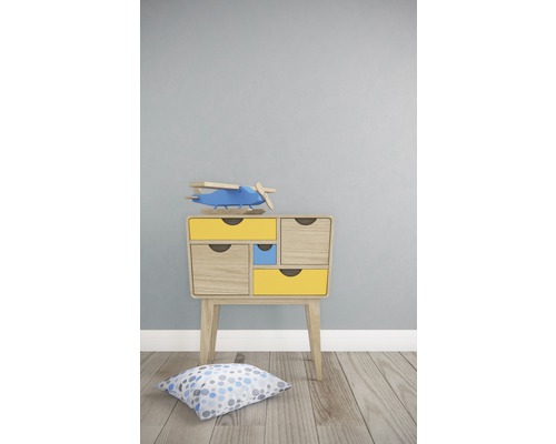 Table de chevet avec tiroirs et avion jouet dans une chambre d''enfant.