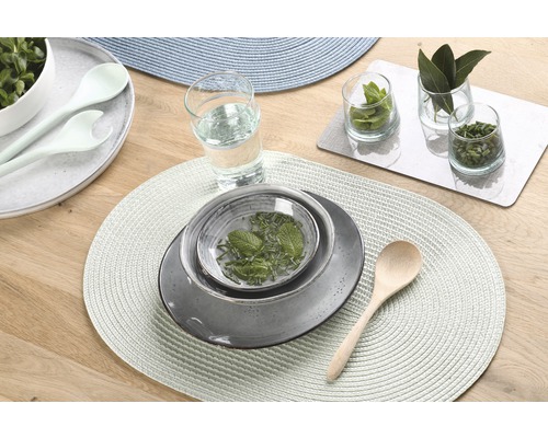 Décoration de table avec assiettes, bols, couverts et verres sur des sets de table