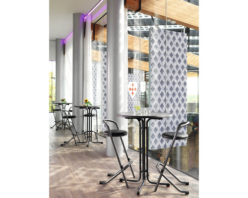 Stehtische mit Barhockern in einem hellen Raum mit großen Fenstern.