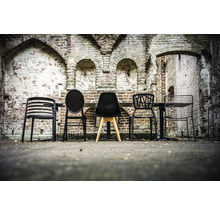 Diverses chaises et une table devant un mur de briques