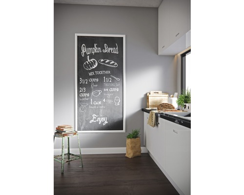 Cuisine claire avec un tableau noir présentant une recette de pain à la courge au mur