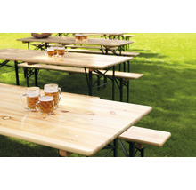 Plusieurs ensembles de tables de bière dans une prairie avec des chopes de bière