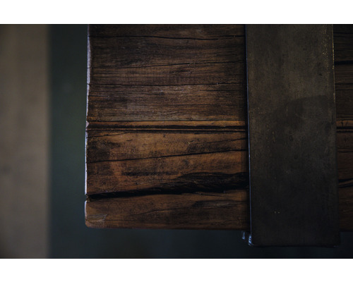 Vue détaillée d''un plateau de table en vieux bois avec une ferrures métallique