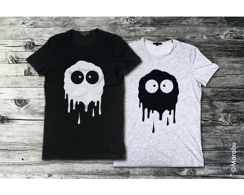Zwei T-Shirts mit Monster-Motiv auf Holzgrund