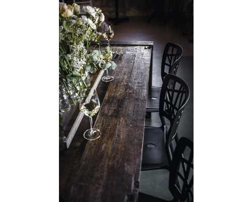 Table de salle à manger en bois avec décorations florales, verres et chaises