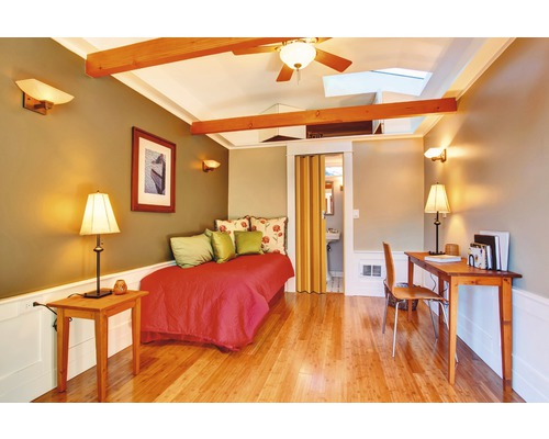 Helles Zimmer mit Tagesbett, Schreibtisch und Holzbalken