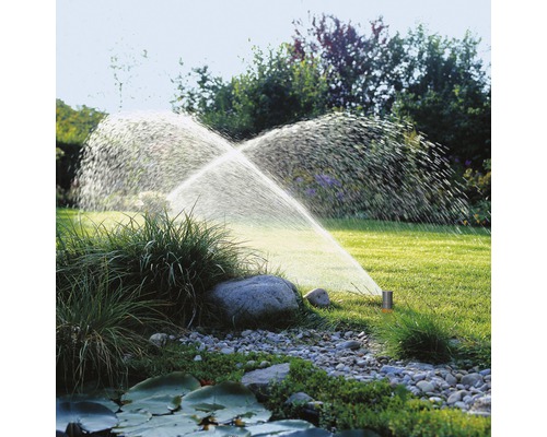 Arrosage de jardin avec arroseur de pelouse en fonctionnement sur une pelouse.